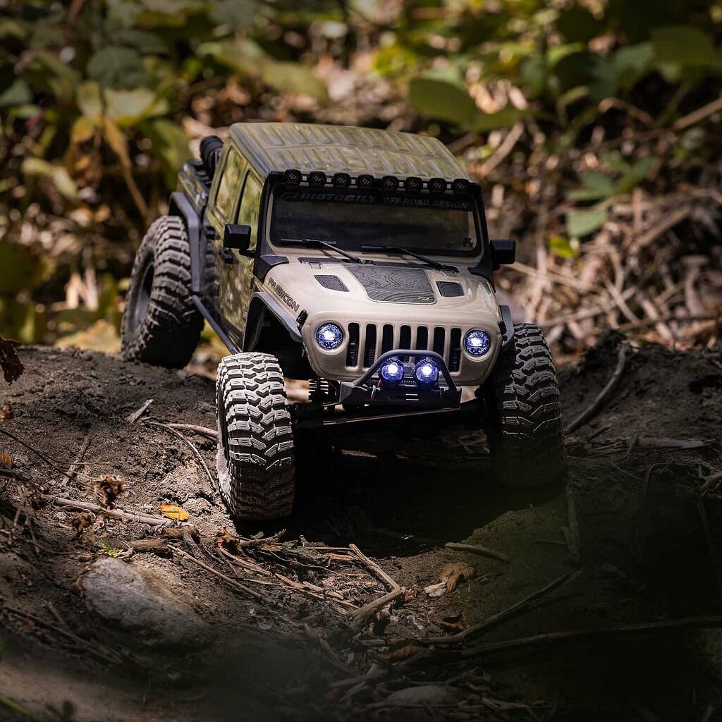 RC Jeep crawling over dirt and rocks in a natural outdoor setting, showcasing off-road capabilities.