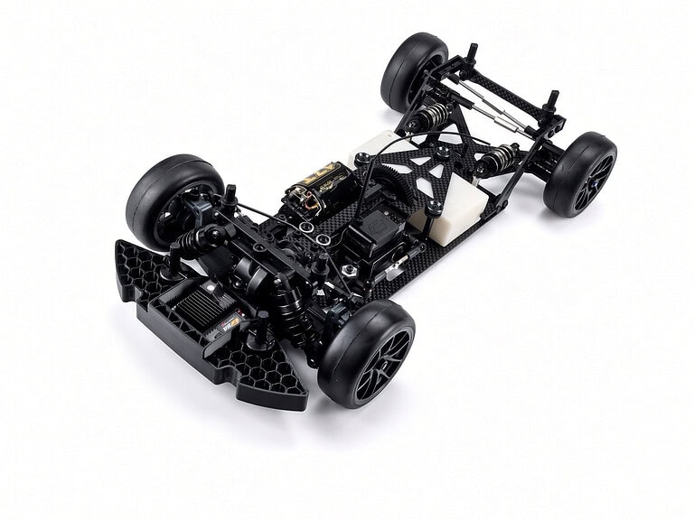 Detailed view of the Carisma M40F FWD mid-motor on-road RC chassis kit with black carbon fiber components and rubber tires.
