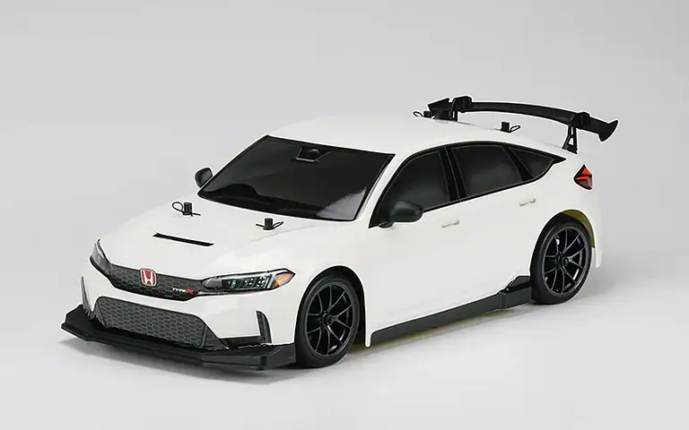 Detailed view of a white RC car featuring a sleek aerodynamic body, black accents, and a rear spoiler, designed for high-speed remote control racing.