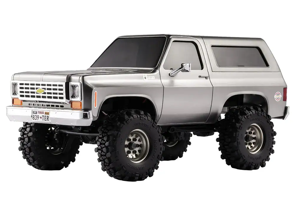 Off-road RC truck model with large rugged tires, silver body, and Chevrolet emblem, ideal for RC enthusiasts and hobbyists.