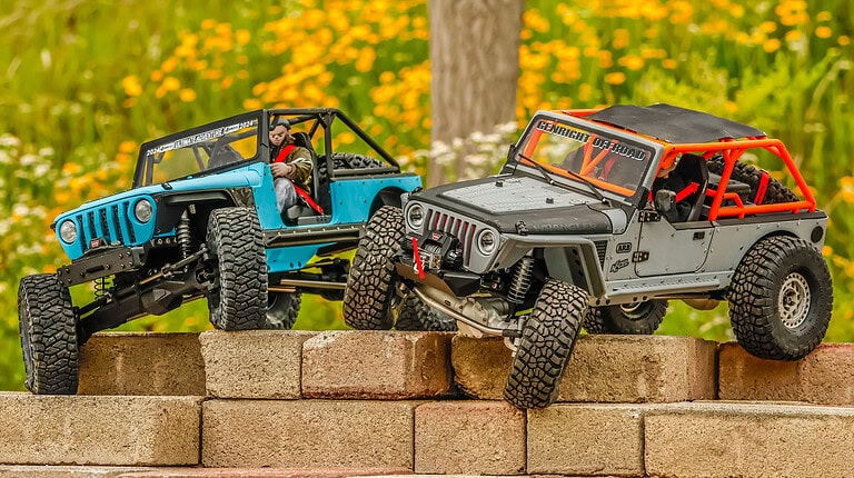 Highly detailed RC off-road jeeps on a brick ledge, showcasing the rugged tires, realistic suspension, and custom modifications, perfect for RC hobbyists and off-road remote control car enthusiasts.