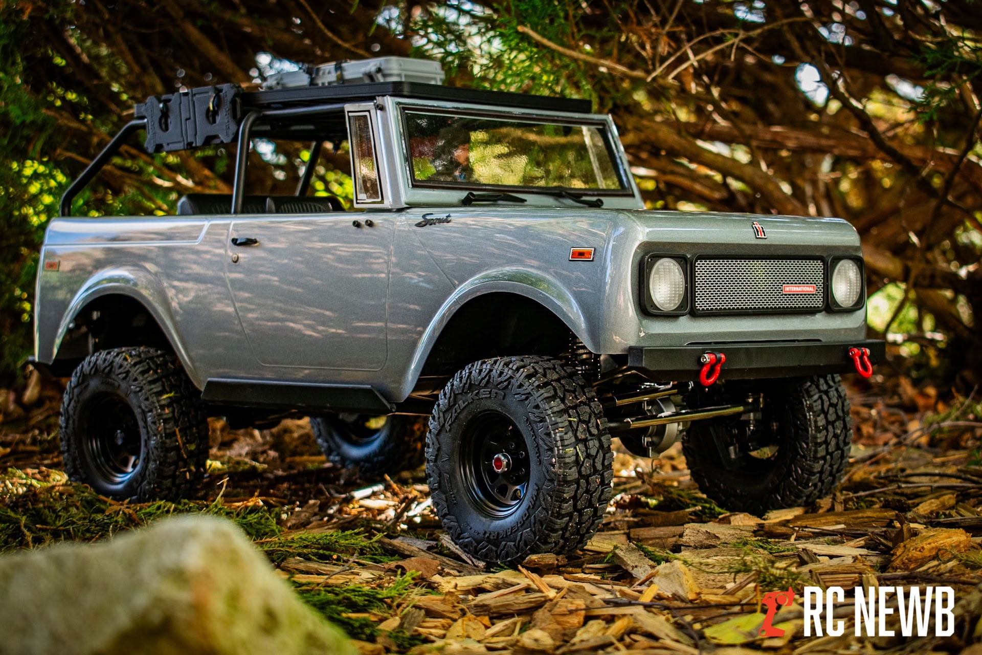 Detailed close-up of a custom RC rock crawler vehicle outdoors, featuring realistic off-road tires, suspension, and a rugged body, perfect for RC hobby enthusiasts and outdoor RC adventures.