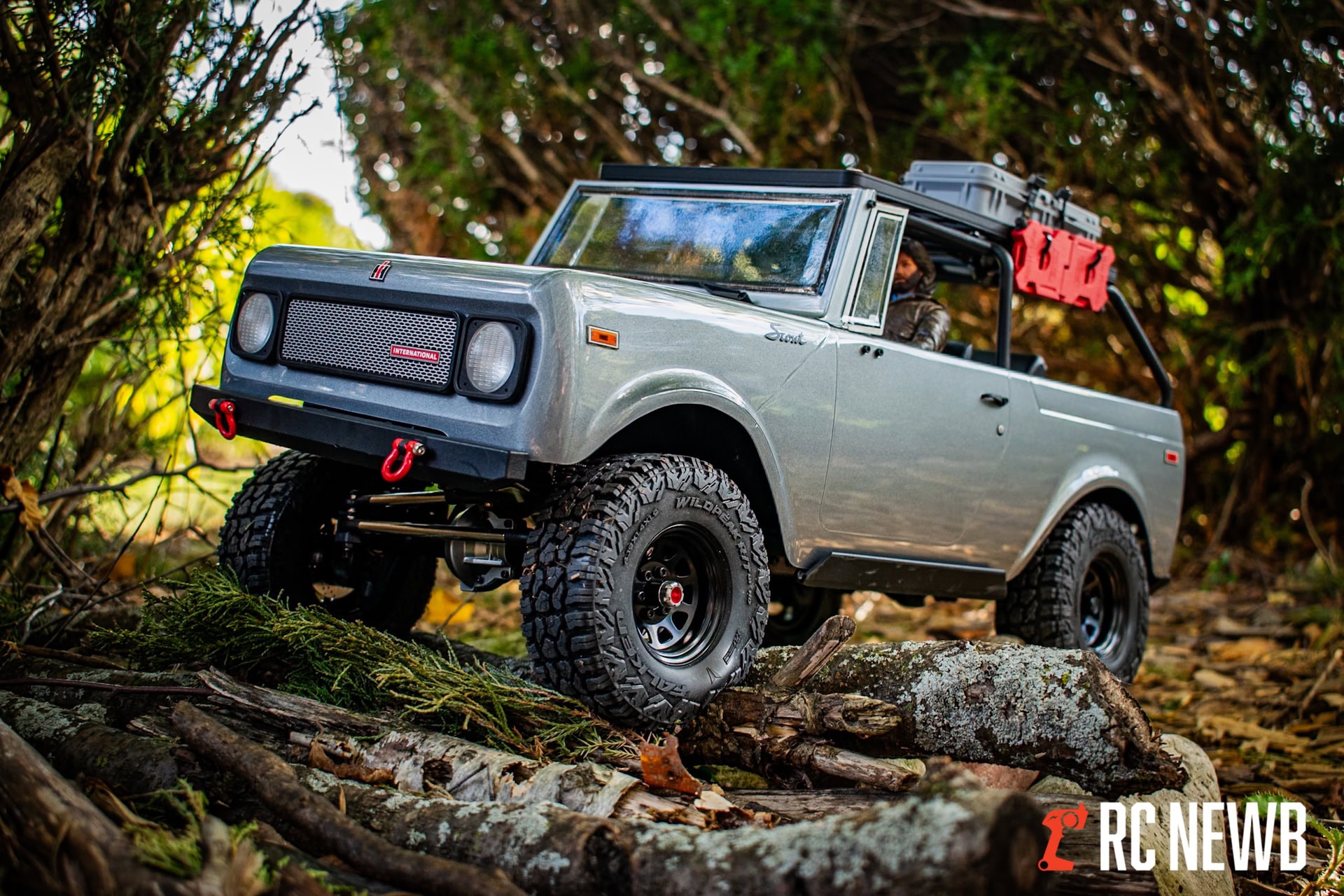 Off-road RC truck navigating through forest terrain with rugged tires and detailed scale features for RC enthusiasts.