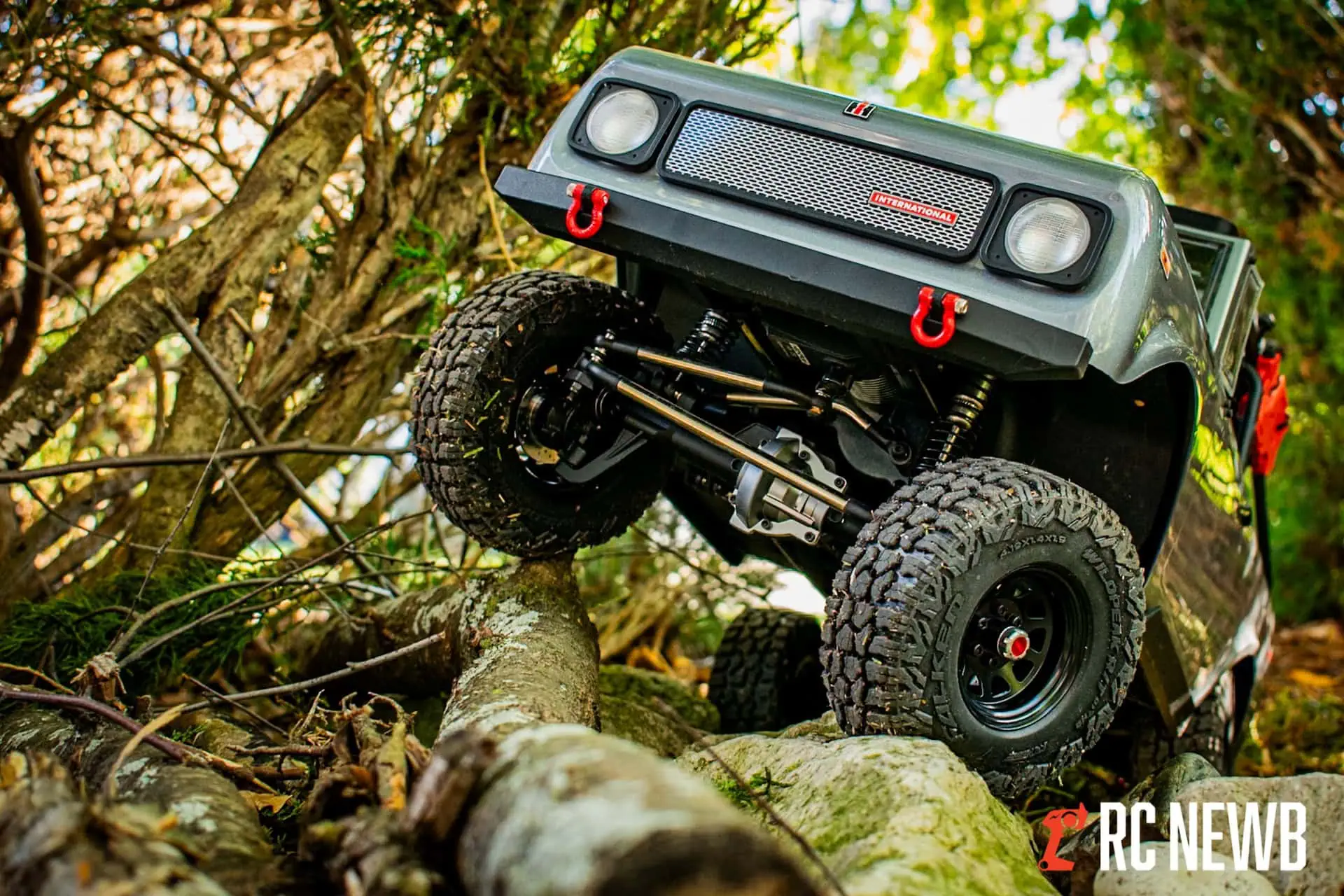 RC off-road truck navigating rocky terrain in a forest setting, showcasing durability and outdoor adventure.