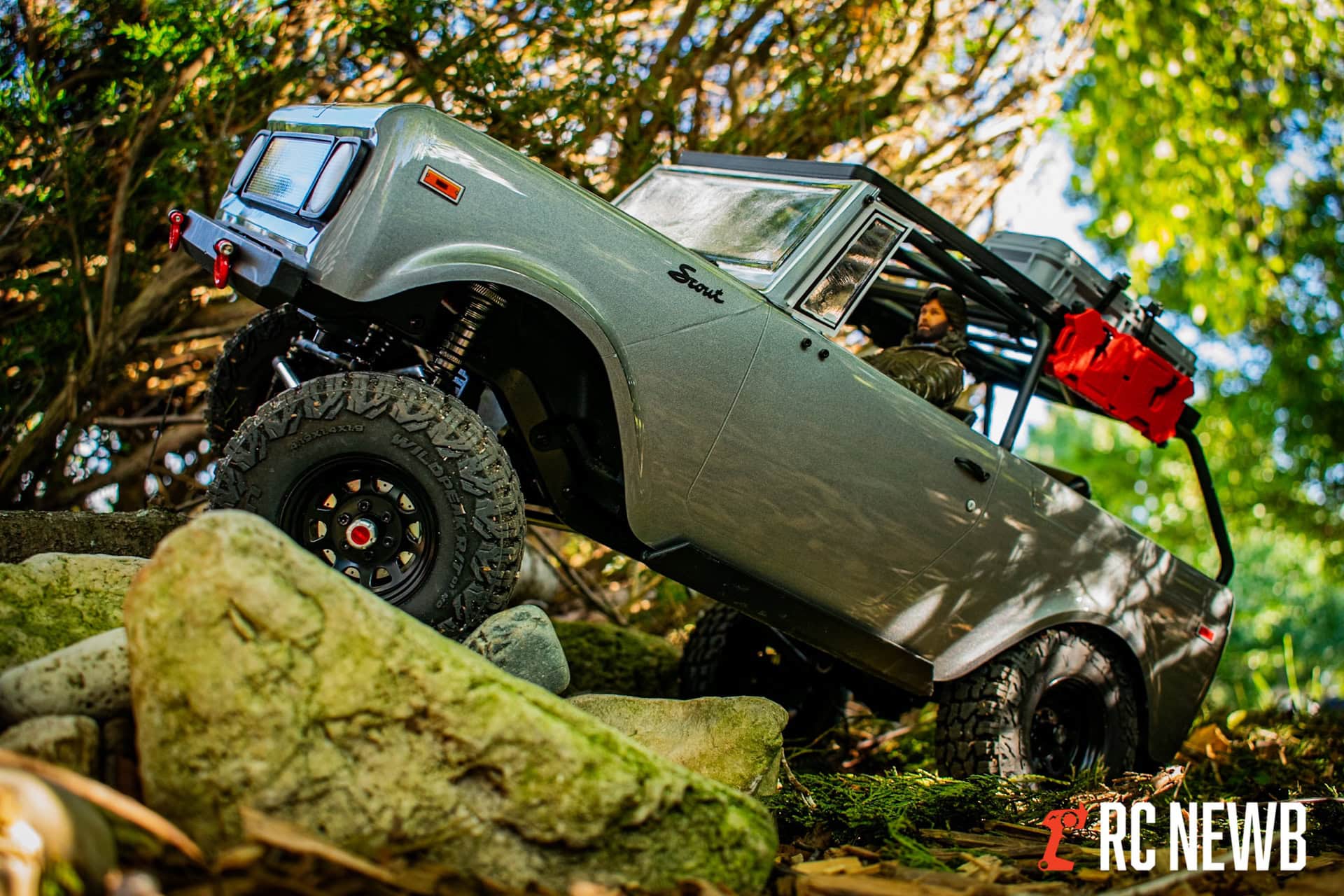 Off-road RC truck navigating rocky terrain in a forest setting, showcasing durability and performance of RC vehicles for outdoor adventure.